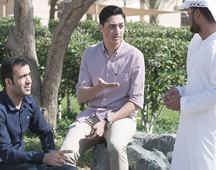 Prospective student discussing confidently on campus at Abu Dhabi University.