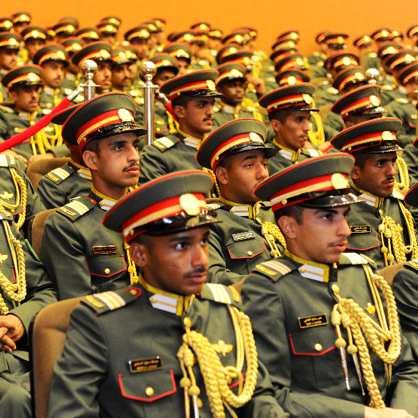 Rows of military cadets in uniform seated at a formal event or graduation ceremony.