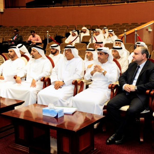 Audience of Emirati officials and professionals attending a formal event in an auditorium.